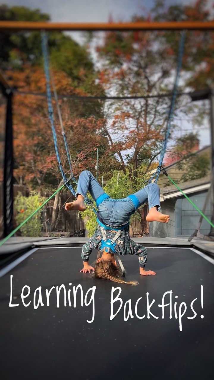 Nothing like a little dad-ingenuity to help her realize her full potential! #fatherdaughter #7yearsold

Backflips, especially on a trampoline, are a mental challenge, not a physical challenge. 

They are easy to do once you understand the simple technique needed but are terrifying to commit to when you’re first trying to learn them.

We have been occasionally working on learning back flips over the last month but I recently overheard Aubrin Sage say “hey siri, how do you do a backflip?” (The kids often ask Siri funny questions) and I realized she was really thinking about them on her own so I decided it was time to dedicate some extra effort to the cause…and that is when the ‘backflip machine’ was born!

Despite many people’s presumptions that she is ‘fearless’, Aubrin is a cautious and calculated human. She thinks intently about what she wants to do and once she puts her mind to it it’s difficult to steer her in any other direction until she accomplishes what she wants. I am also keenly aware of the lasting effects a scary situation or painful fall can have on a child’s mind so I enjoy finding creative solutions that support her and allow her to accomplish her goals as safely as possible. 

Is this a bit ‘extra’? Yes. But it’s been so much fun to create this with her and watch it help her get over the fear and work on her technique and it appears to be pretty helpful so I’m going to say this little project was a success!

This whole experience in the video escalated quickly, from being too scared to commit to flipping over backwards to tossing over 25 backflips which happened in the span of 10 minutes and I’m so proud of her for getting to this point!

She’s SO CLOSE to completing her backflip journey and the final step is to get up the courage to finally commit to the backflip with no safety tethers but I know first hand just how scary that is.

I just posted a video response explanation of this crazy beam-rope-bungee contraption to the pinned comment.🤙